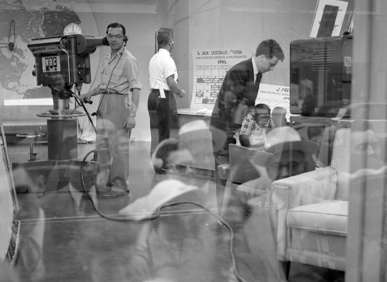The set of NBC's \"Today Show\" is seen though a reflection of people outside peering into the window in April of 1954.